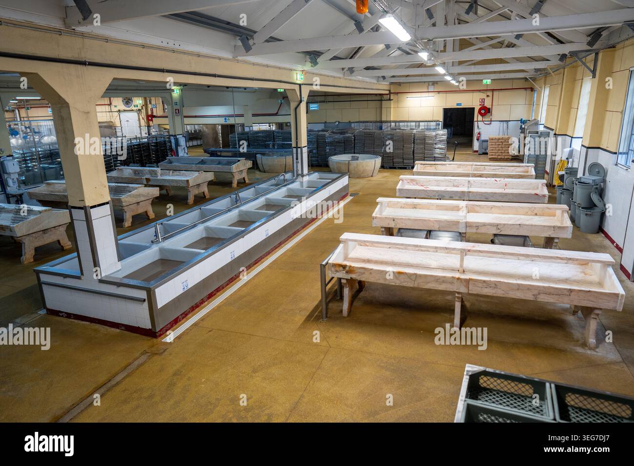 Empty fish cleaning tables, tiled washing sinks and stacked racks ...