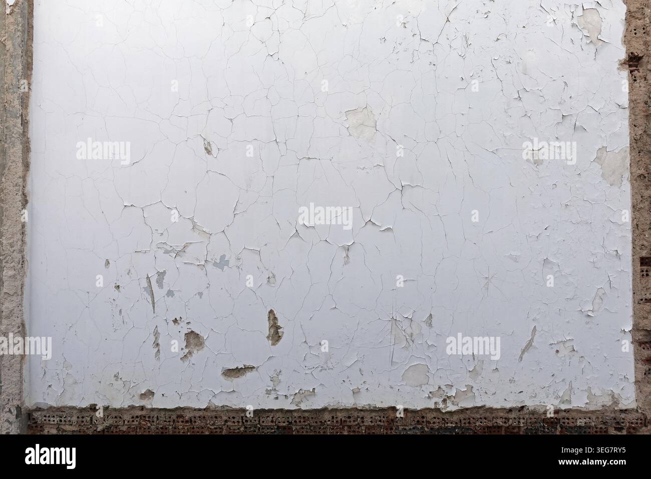 Empty weathered white wall background with exposed bricks and concrete frame. Stock Photo