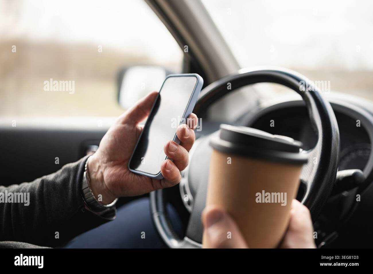 Driver Holding Smartphone And Coffee Cup While Driving Stock Photo
