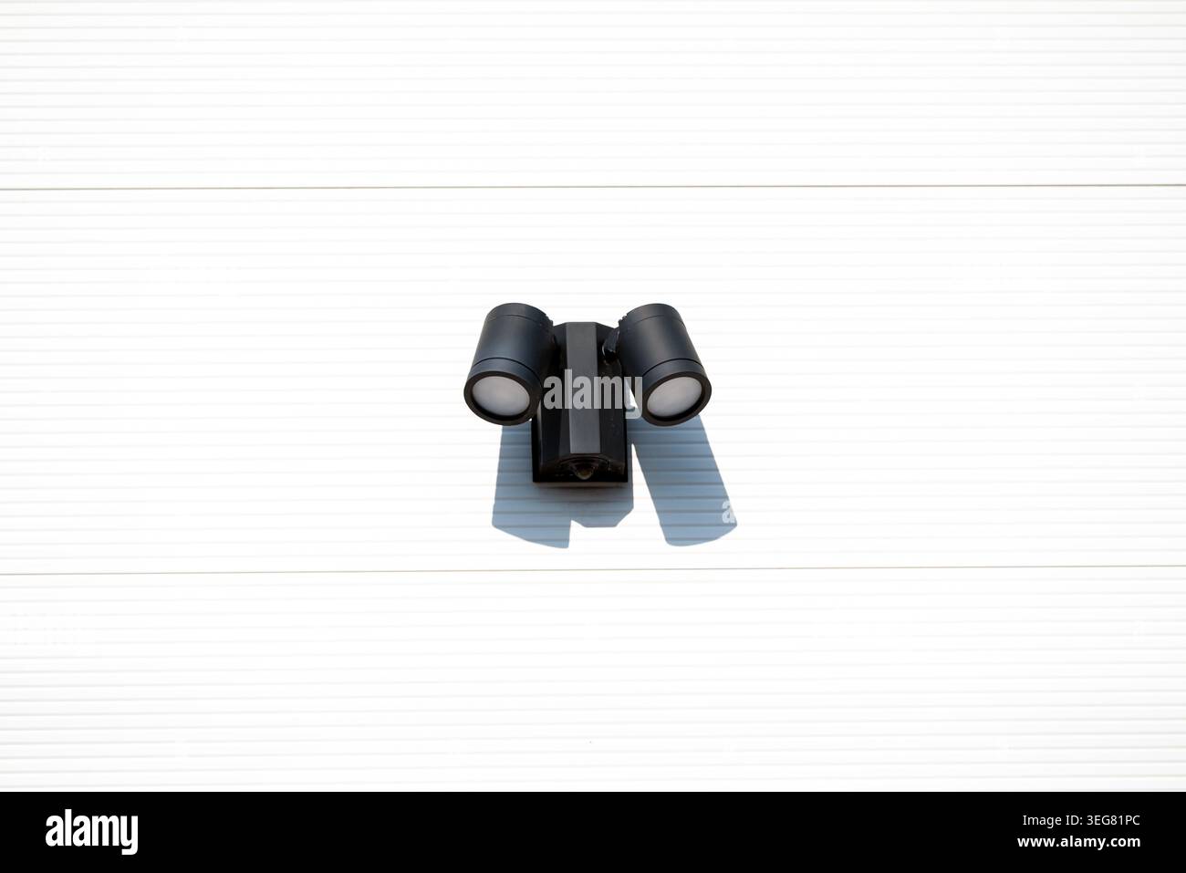 Outdoor LED Security Spotlight with Motion Sensor Mounted on Exterior Wall Stock Photo