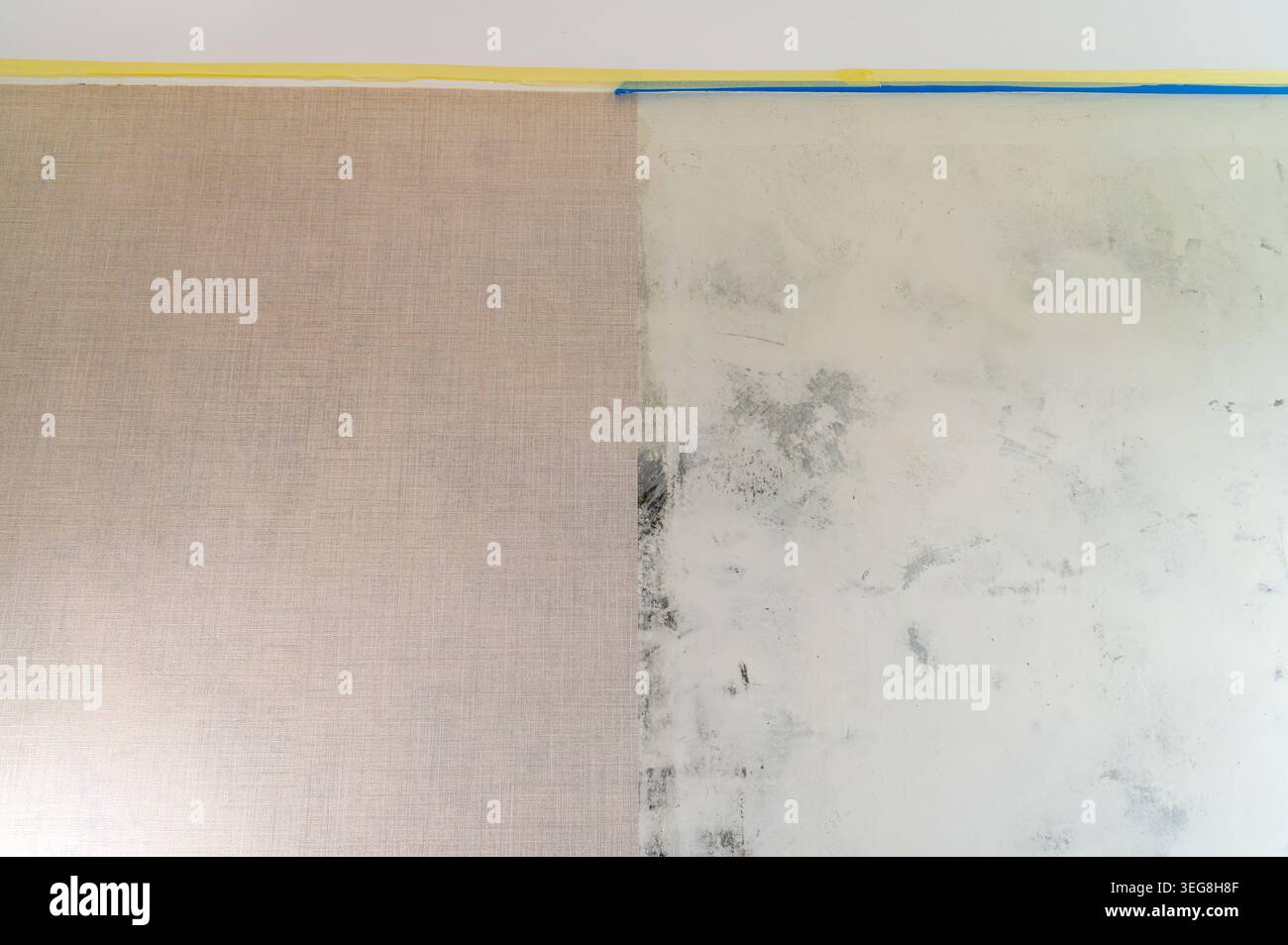 Wall half covered with wallpaper beside unfinished plaster surface. Stock Photo
