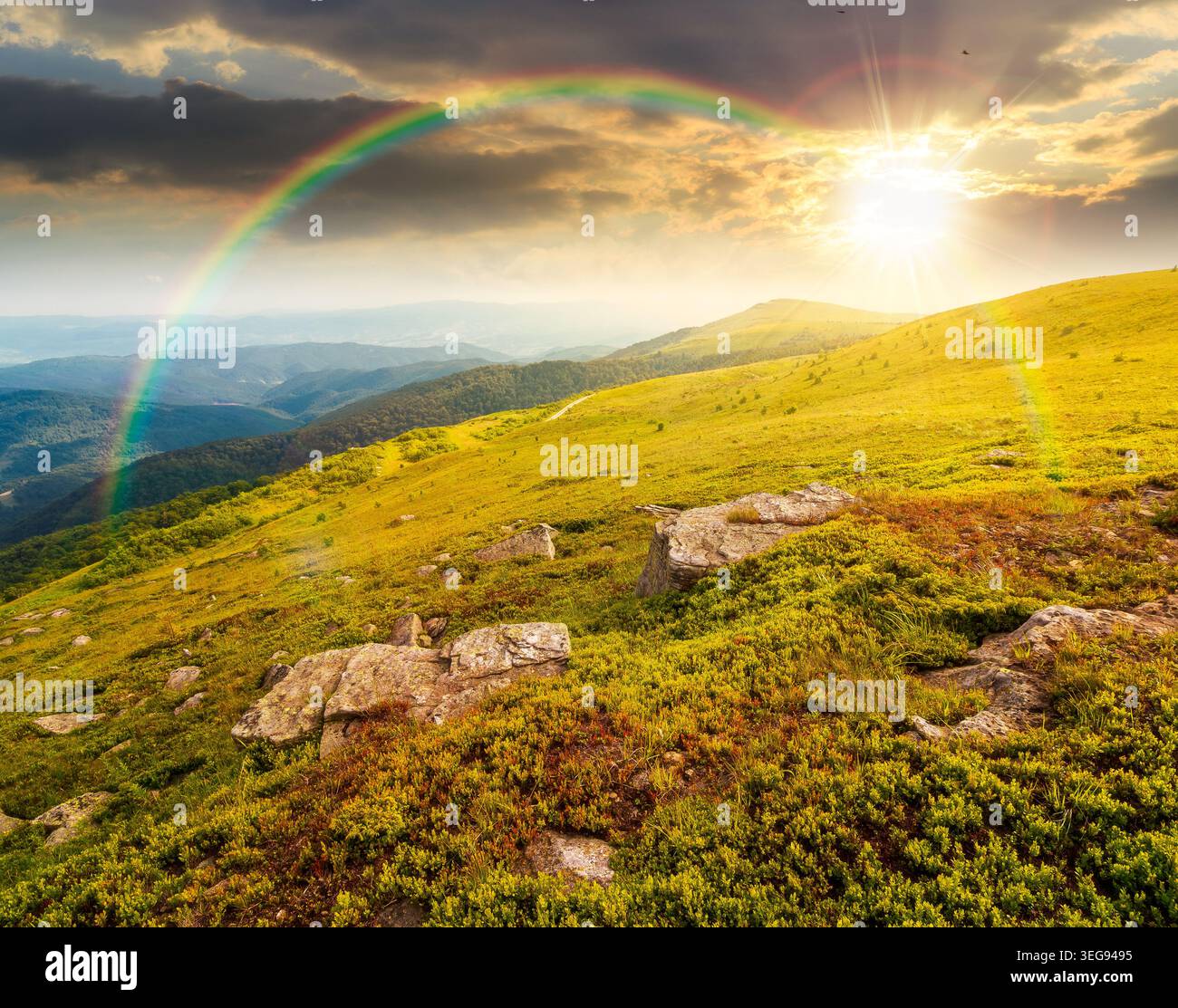 sunset over mountain summer landscape. meadow with giant stones among the grass on the hillside. awe view near the peak of mountain smooth in evening Stock Photo