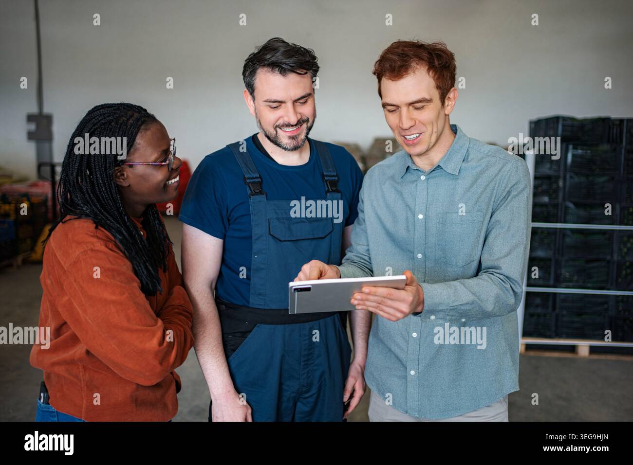 Warehouse workers collaborating on digital tablet for logistics management Stock Photo
