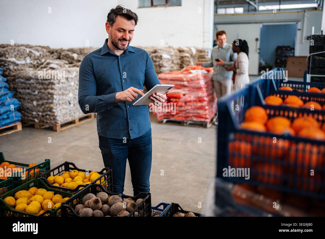 Man using tablet checking inventory in food warehouse Stock Photo