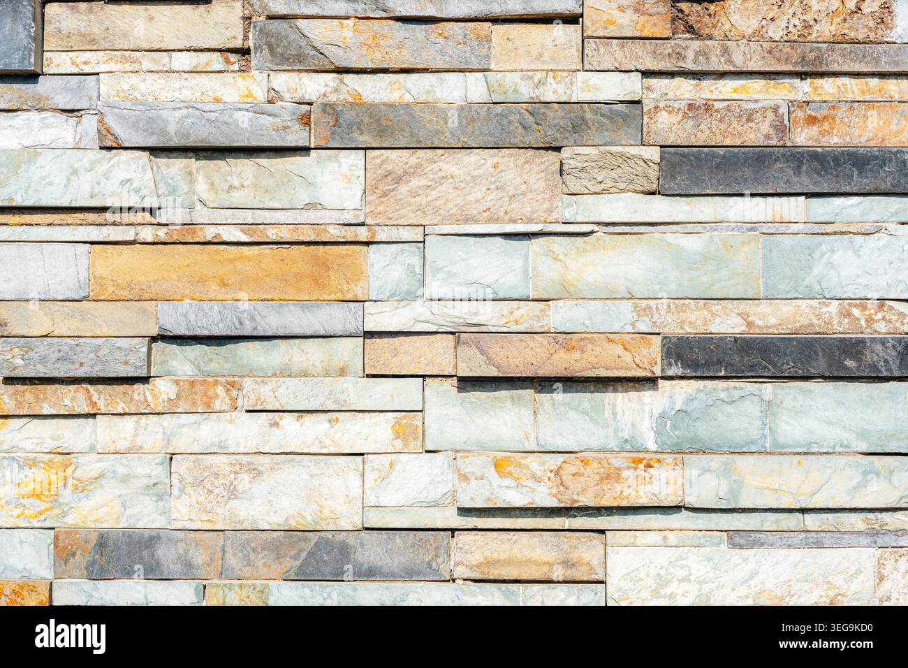 Layered stone wall texture with natural tones. Rough surface pattern background for construction and design Stock Photo