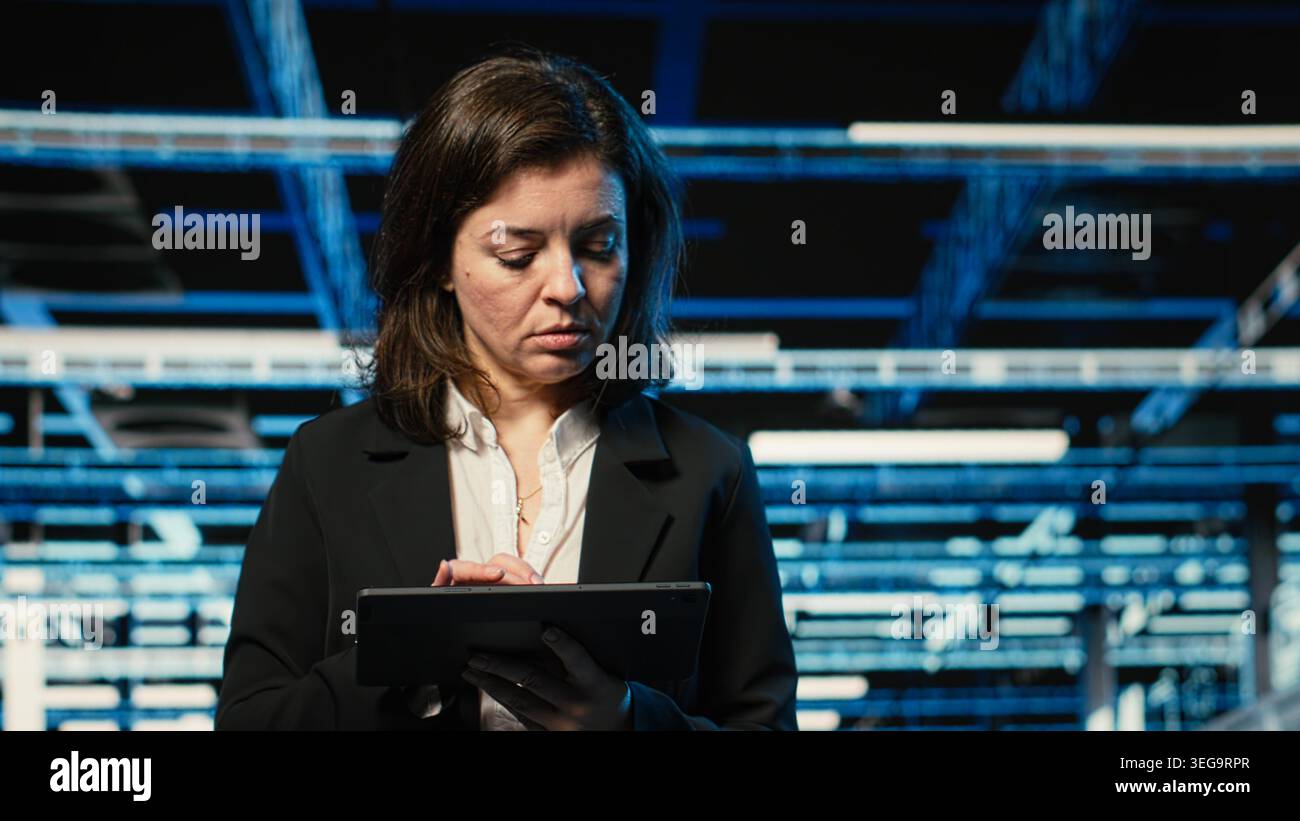 Close up of data center DevOps engineer optimizing server load balancing using tablet. Server farm worker adjusting system parameters on device to improve efficiency Stock Photo