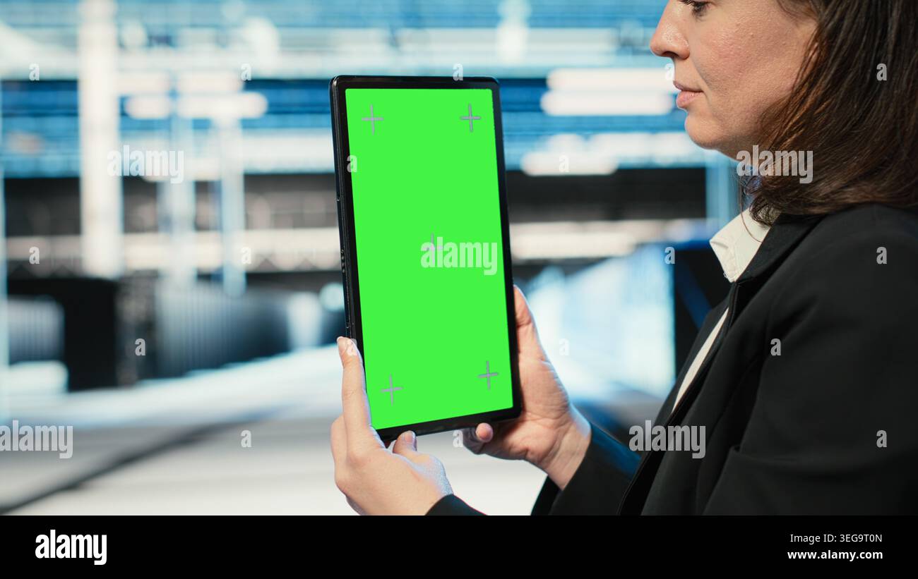 Green screen tablet used by data center admin to optimize server load balancing. Server farm IT specialist using mockup device to adjust system parameters and improve efficiency Stock Photo