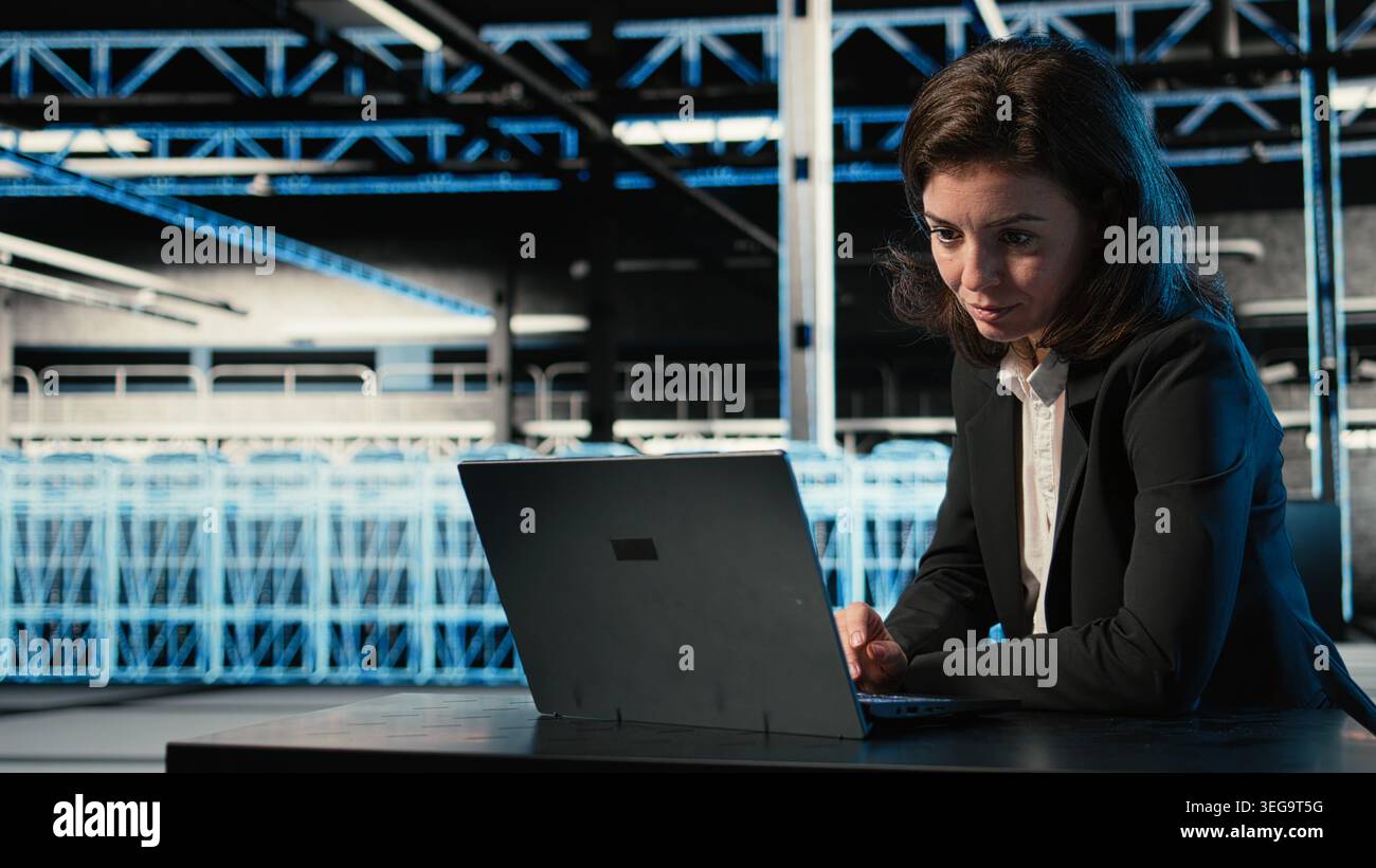 Optimizing server, laptop and software developer in data center doing load balancing. Adjusting system parameters, notebook and woman in server farm at desk improving efficiency Stock Photo