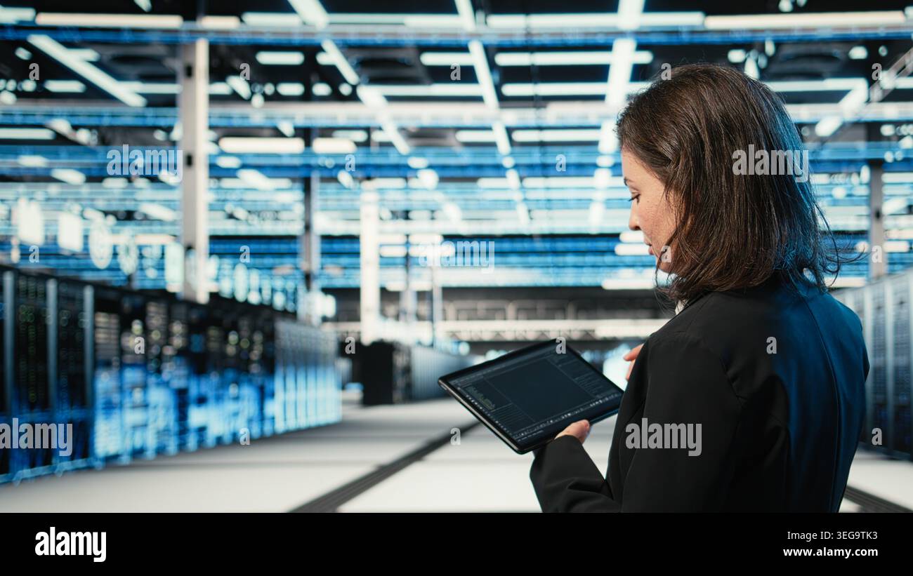 Data center programmer coding on tablet, optimizing equipment rigs using application. Close up of IT professional in server hub running programming script, adjusting system parameters Stock Photo