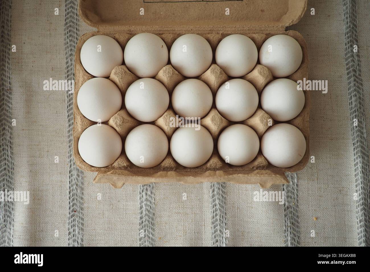 Eggs placed neatly in a carton on a kitchen table Stock Photo