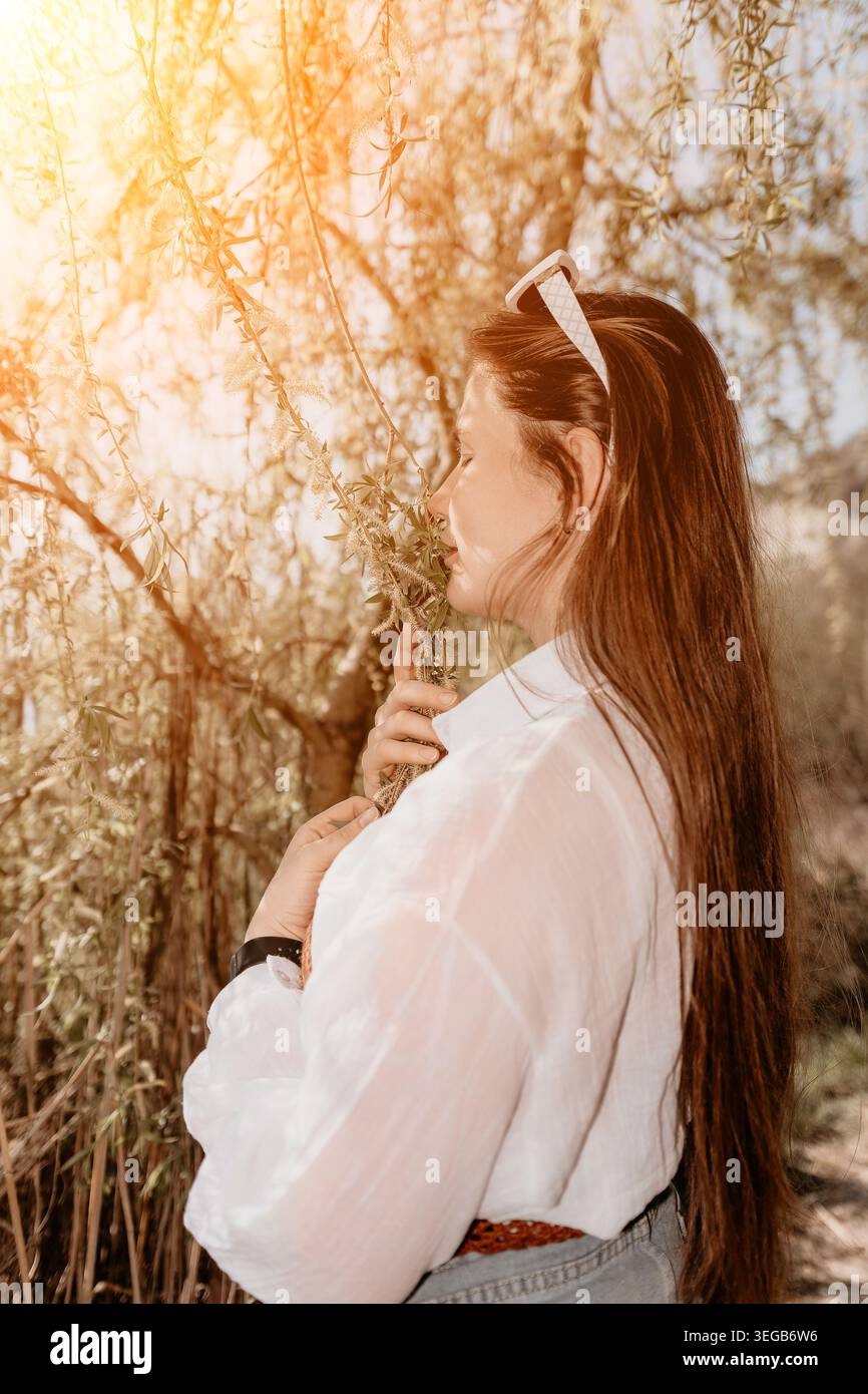 Woman nature sunlight enjoying the golden hour while smelling spring ...