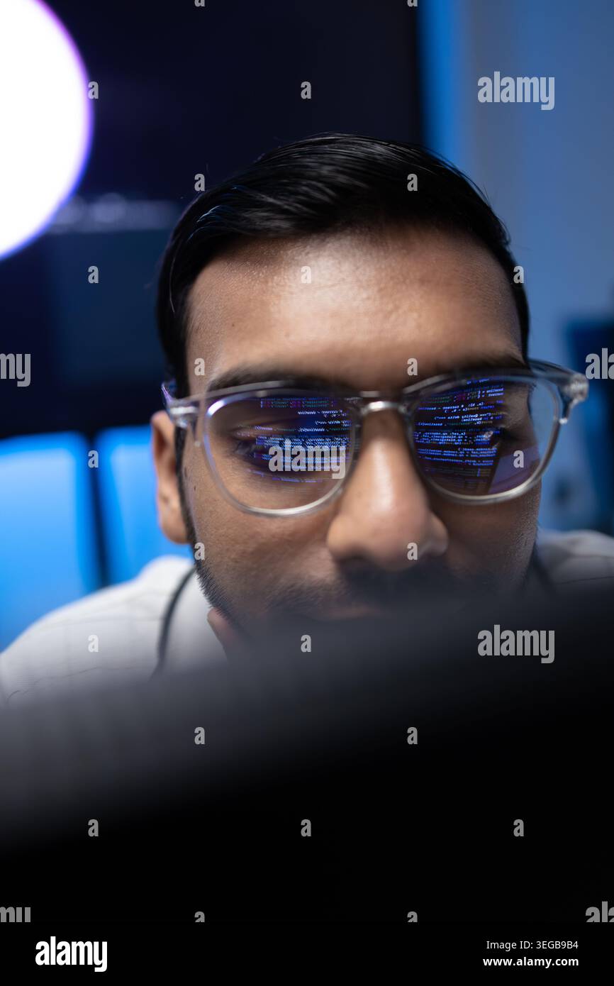 Vertical Portrait Of Indian Software Developer With Code Reflection On Glasses Stock Photo
