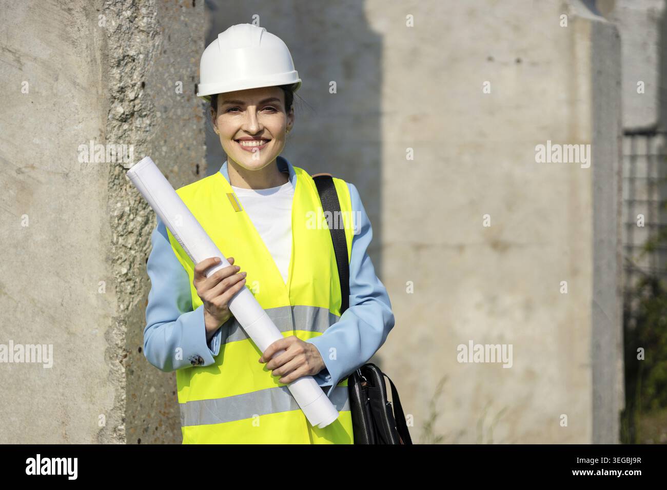 Portrait of a happy female architect holding blueprints on a construction site, on her first major project. Copy space Stock Photo