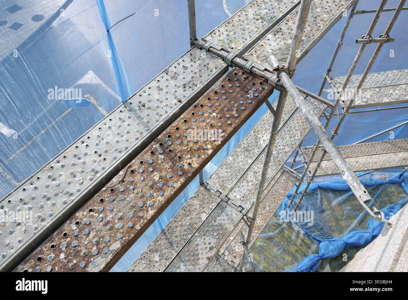Scaffolding structure providing temporary access with platforms and protective netting Stock Photo