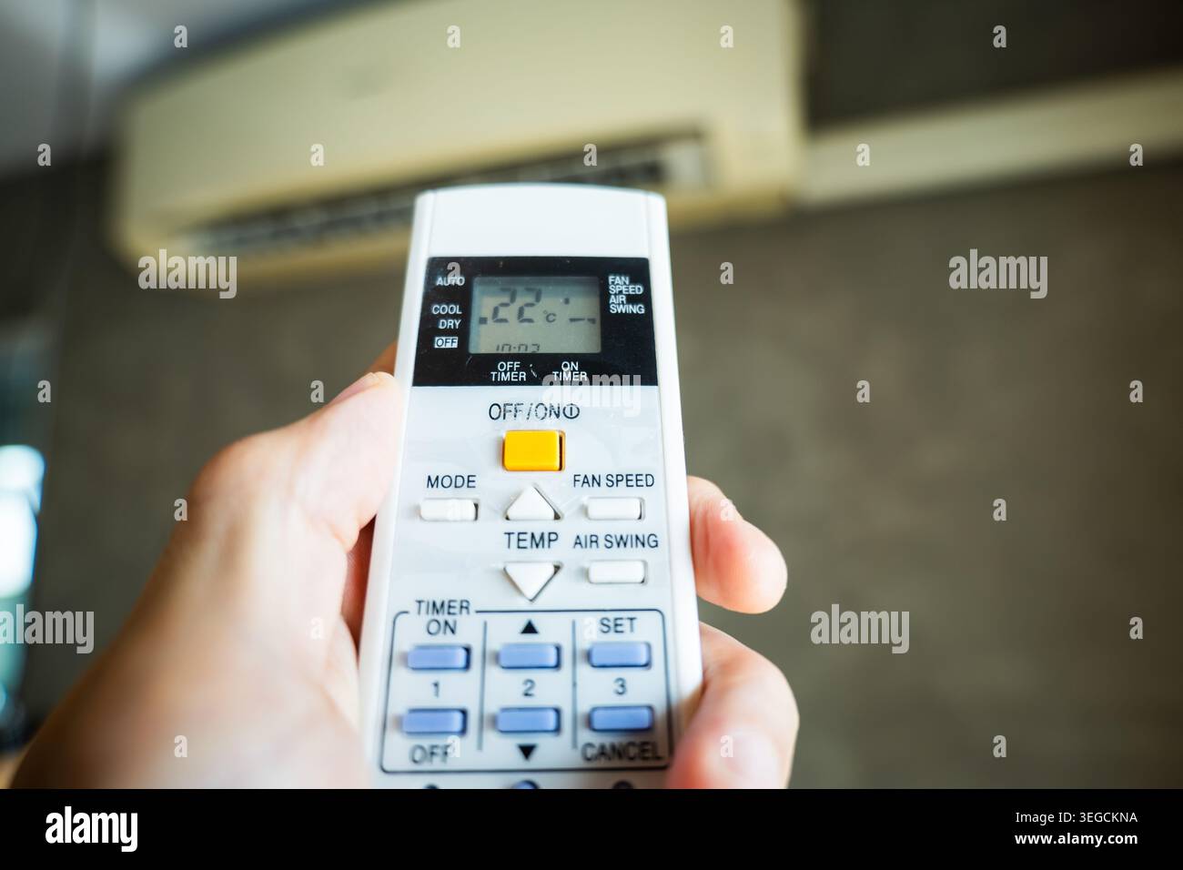 Air conditioner temperature adjustment with remote controller in room at home Stock Photo