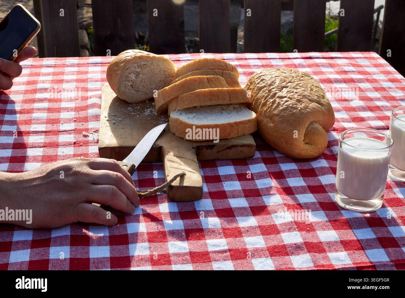Man Using Smartphone During Rustic Countryside Breakfast Stock Photo