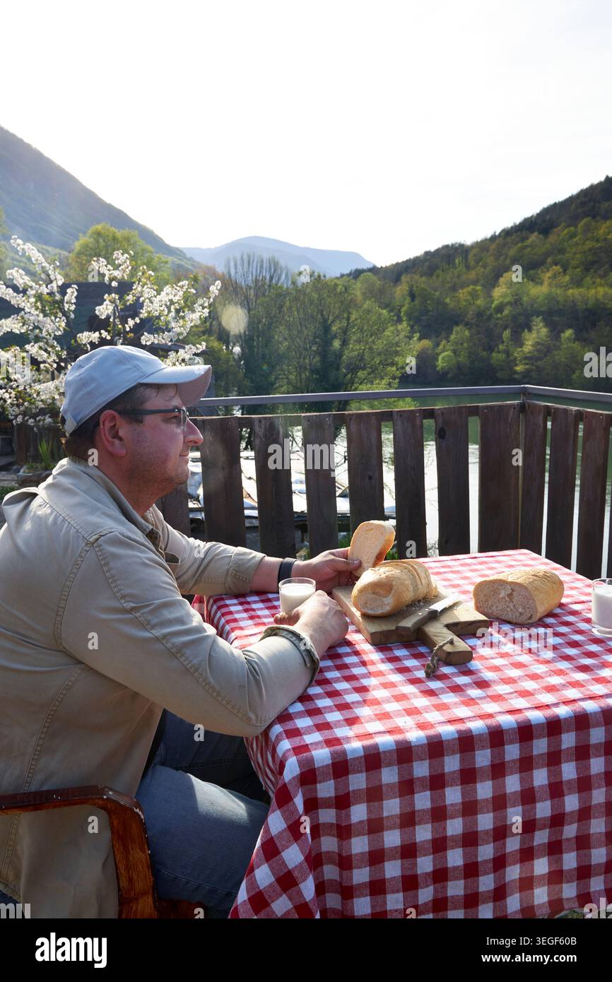 Man Using Smartphone During Rustic Countryside Breakfast Stock Photo