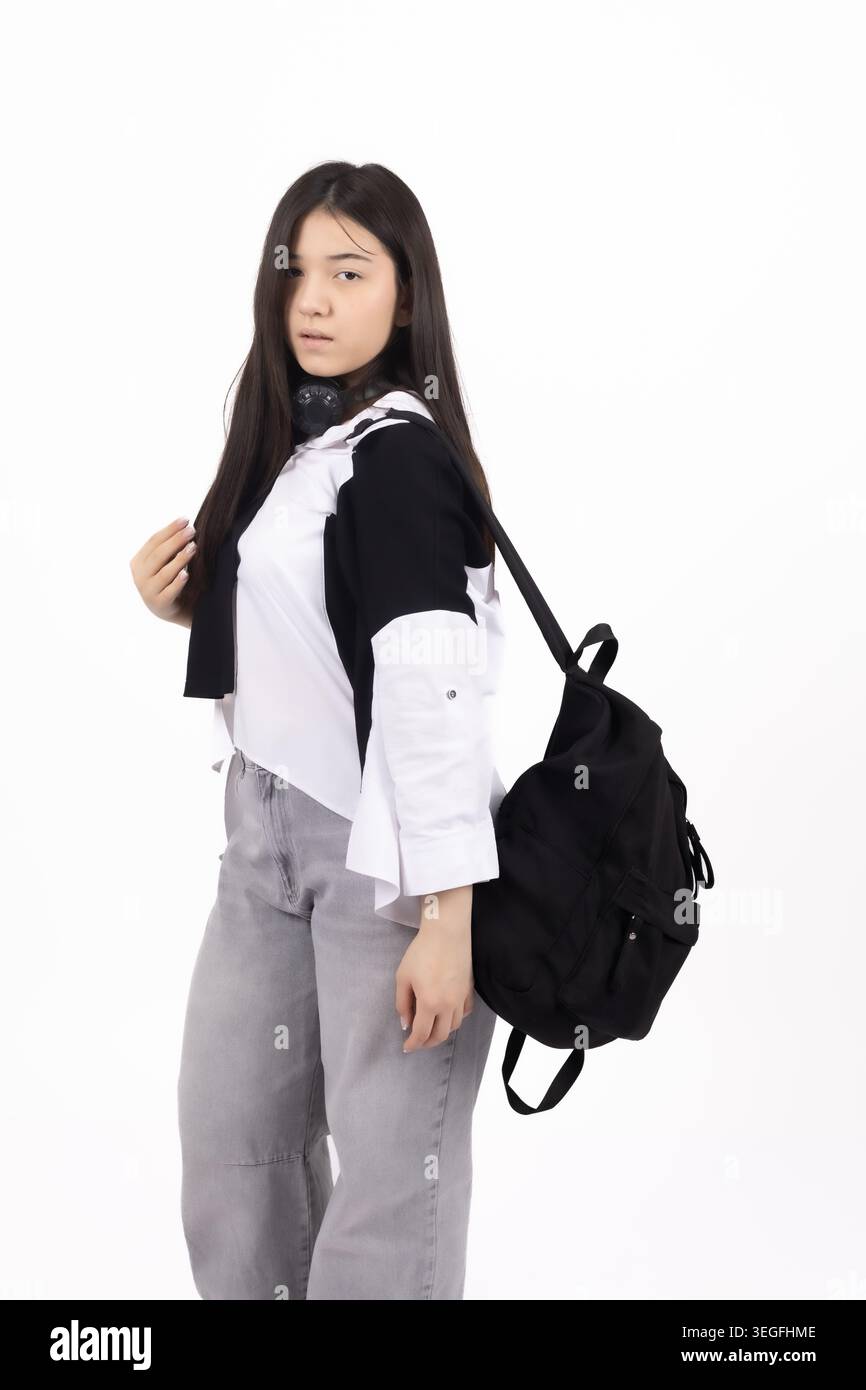 Young stylish woman standing with a black backpack in studio Stock Photo