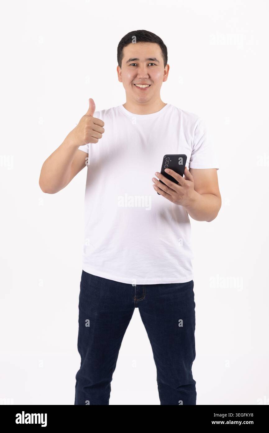 Happy handsome young man talking on smartphone holding thumb up Stock Photo