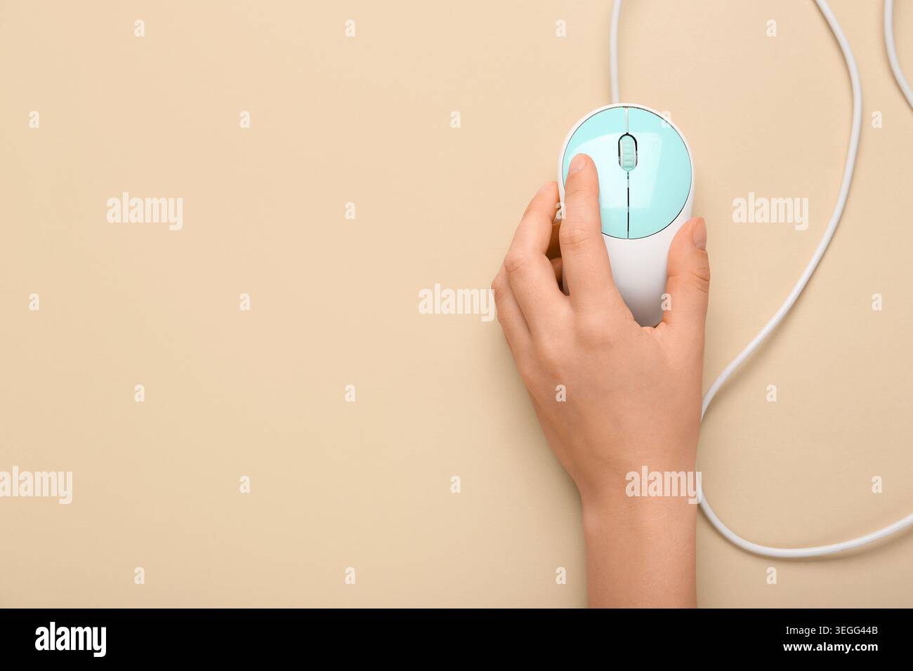 Female hand with modern computer mouse on beige background Stock Photo