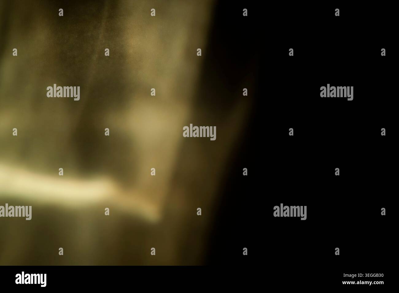 Abstract sepia golden light leak texture fading into dark black background Stock Photo