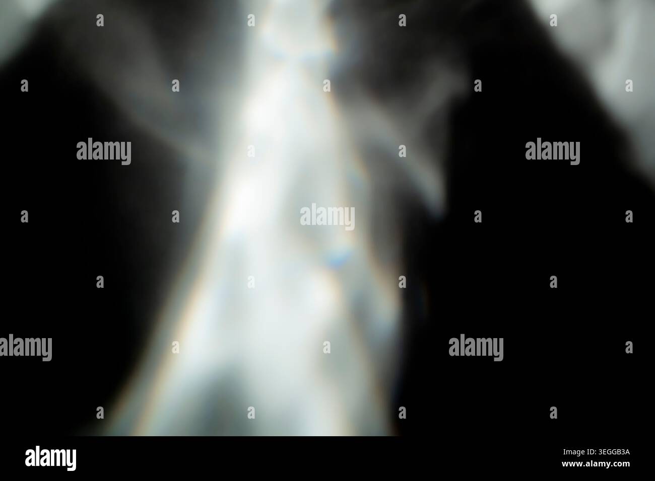 Soft blurred white light rays and subtle lens flare effect on a black background Stock Photo