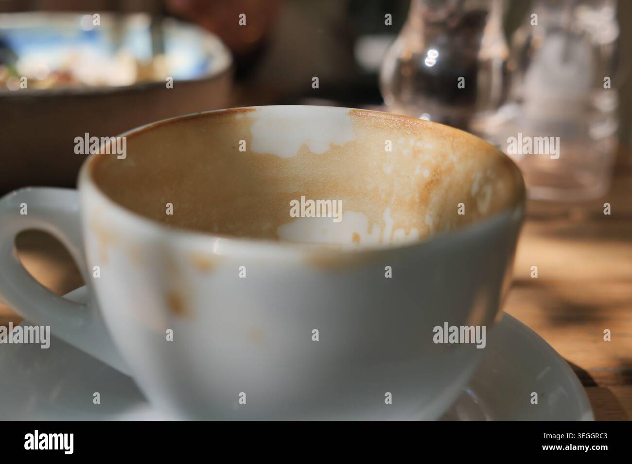 Coffee cup sits empty after a morning drink Stock Photo