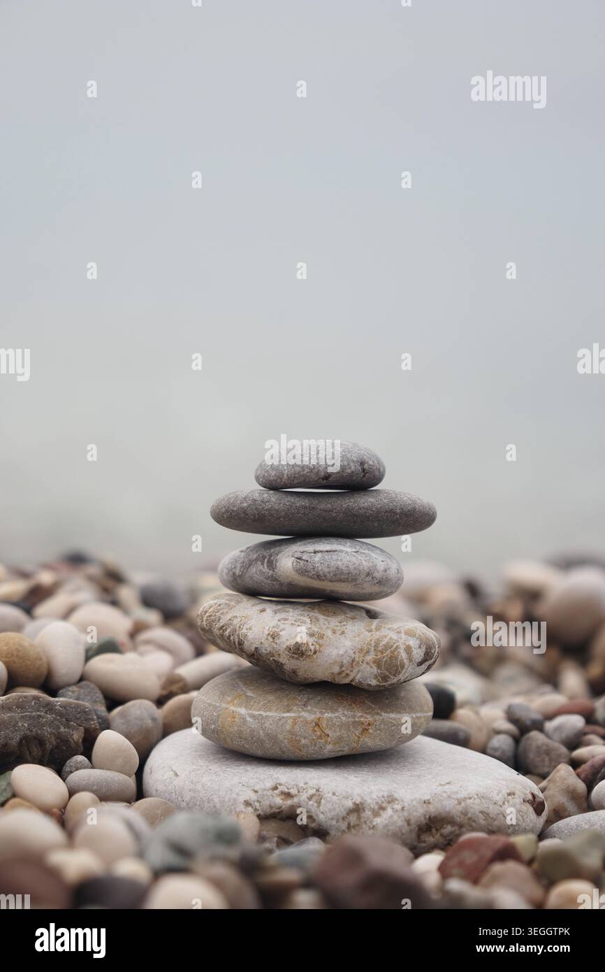 Balanced stone stack on pebble beach near water Stock Photo