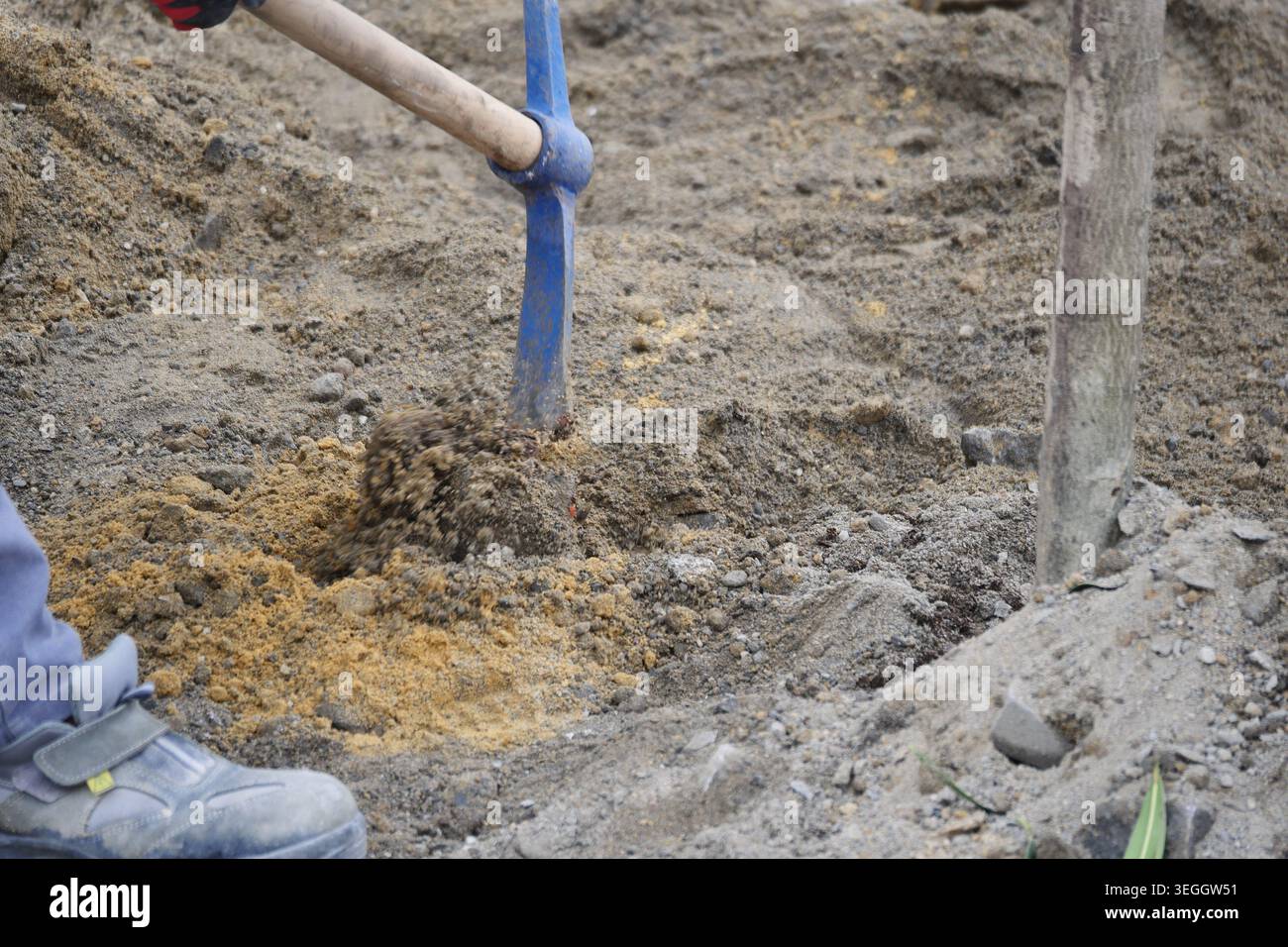 Worker digs a hole in the ground using a shovel Stock Photo