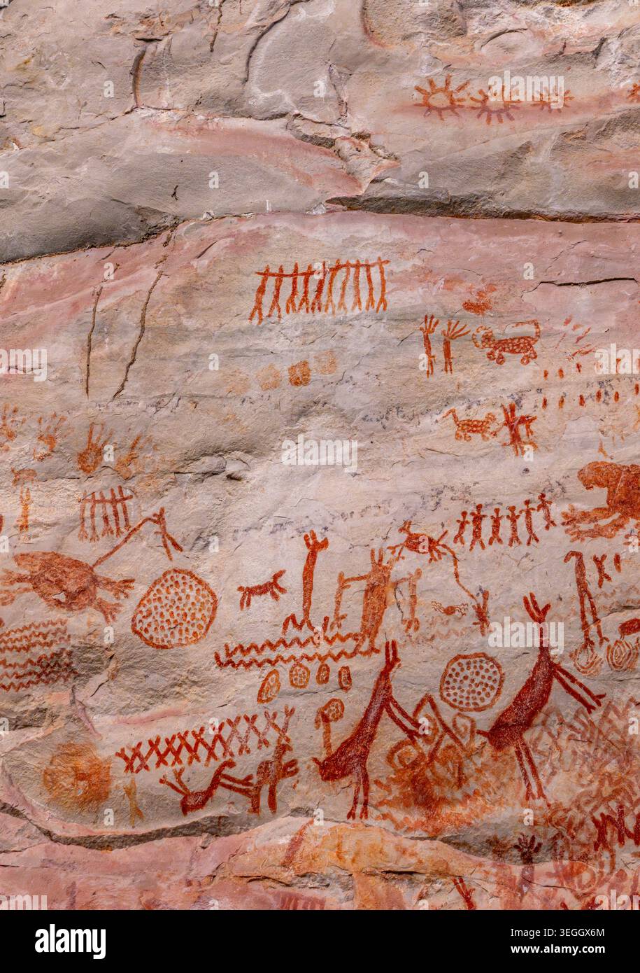 Ancient rock art depicting figures and animals in vibrant red hues on a ...