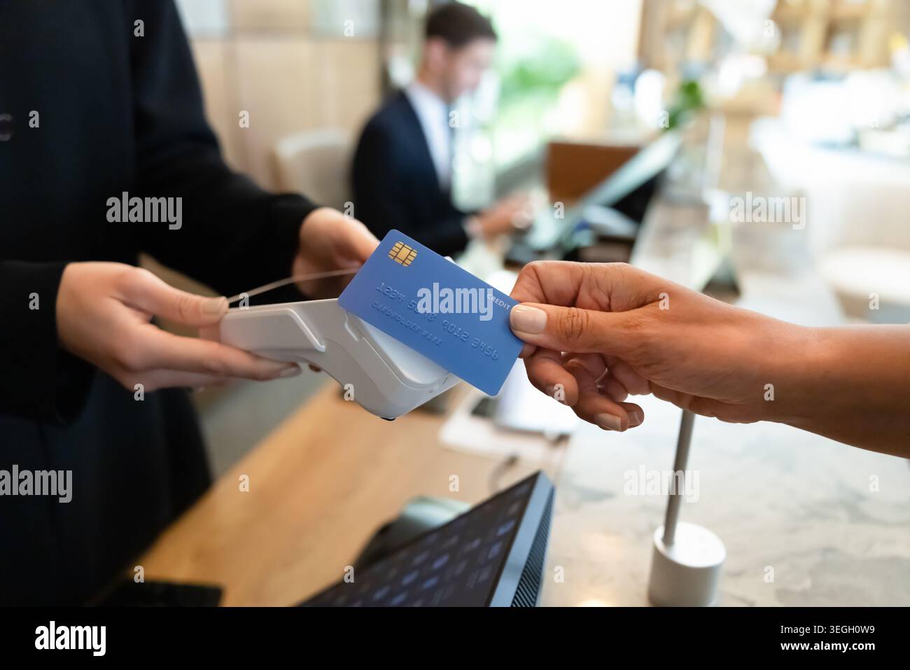 Customer making contactless payment at retail counter Stock Photo