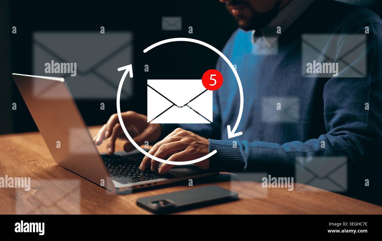 Working on laptop and checking email notifications in a home office setting Stock Photo