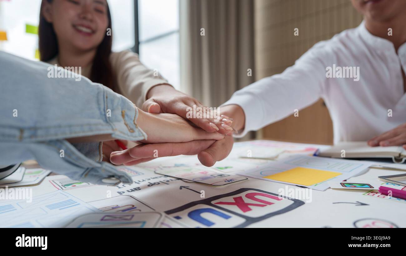 Asian business team showing teamwork and unity in office for project success. Stock Photo