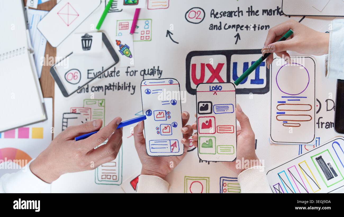 Asian design team collaborating on UX UI mobile app interface mockups Stock Photo
