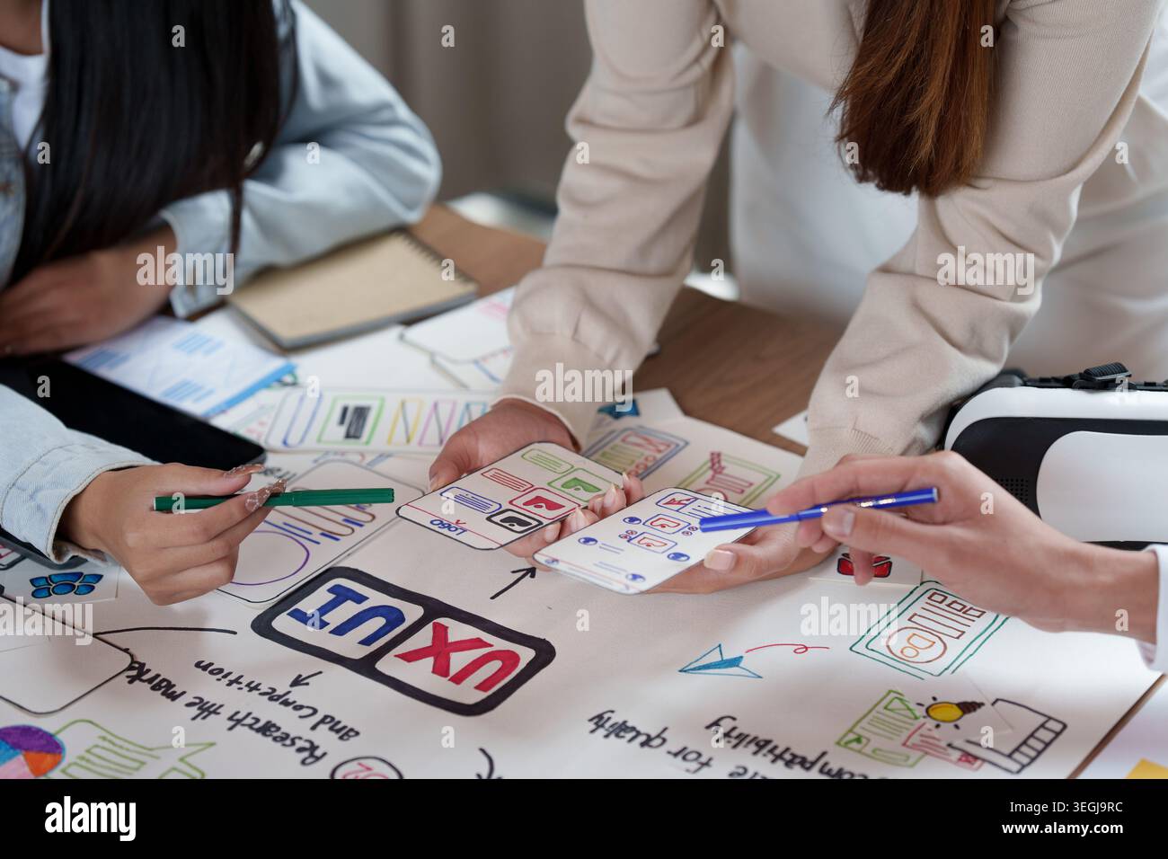 Three people collaborating on UI UX design for mobile app development Stock Photo