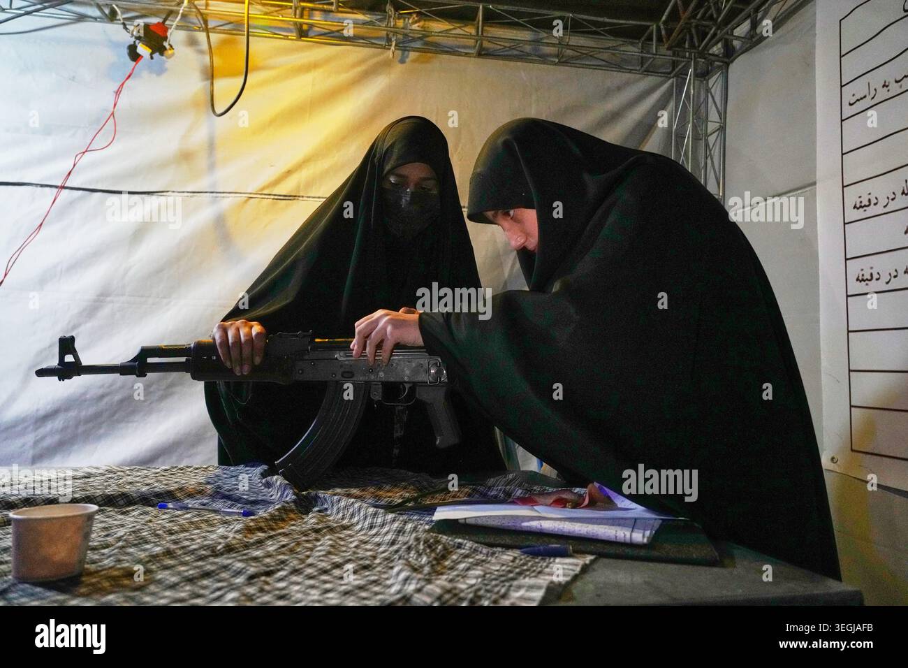 A member of the Revolutionary Guard's volunteer Basij force shows how ...