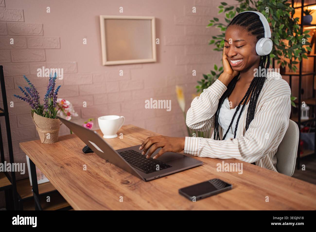 Young adult woman smiling and listening to music using headphones and ...