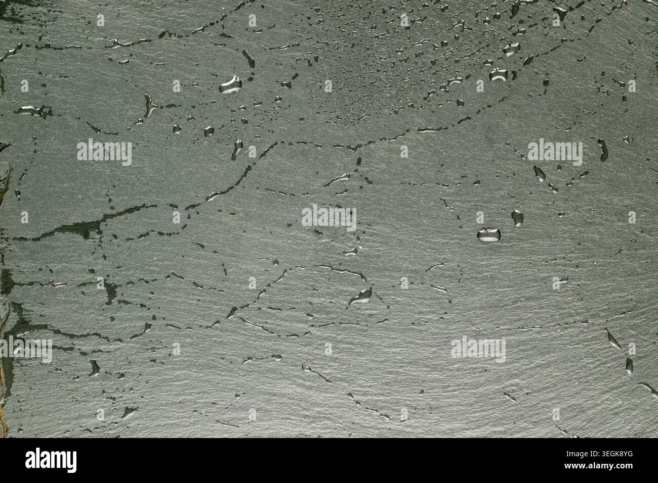 Slate stone surface with water drops, macro, top view. Stock Photo