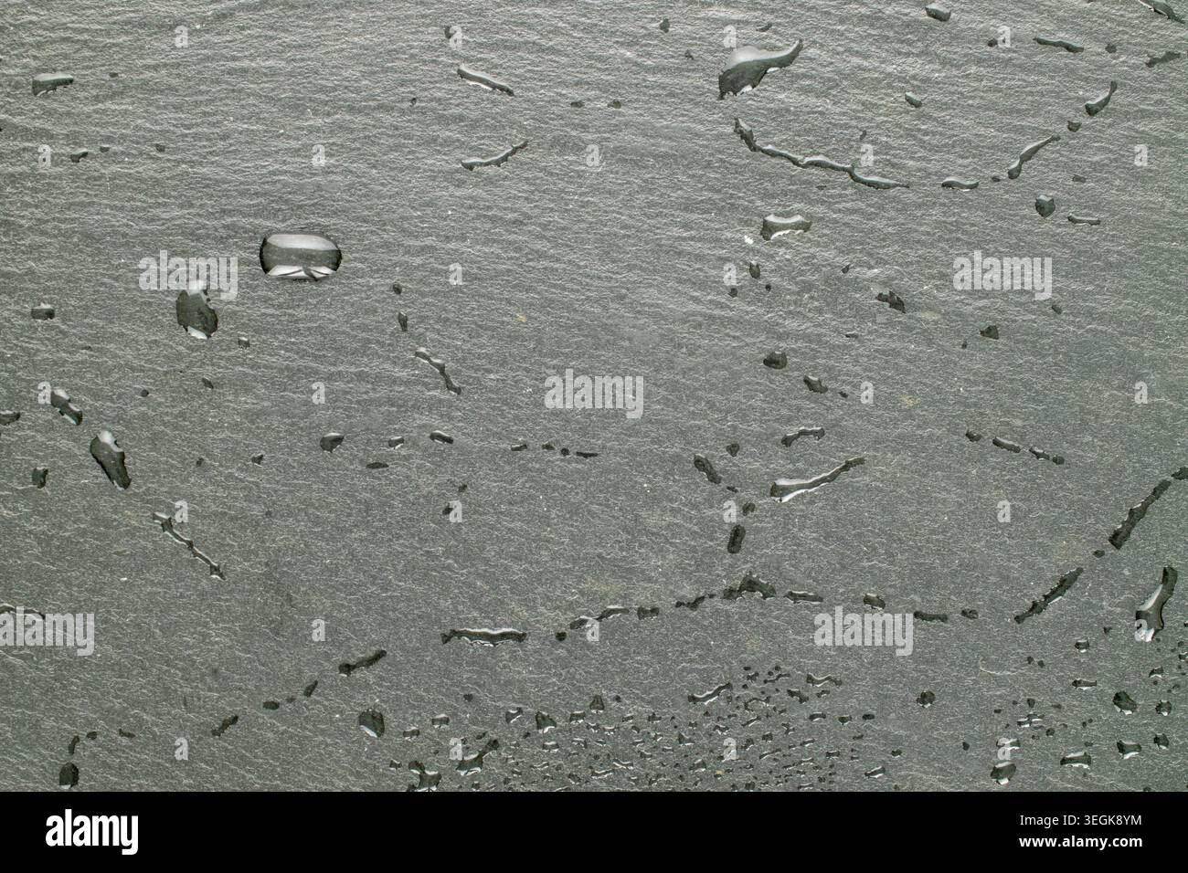 Slate stone surface with water drops, macro, top view. Stock Photo