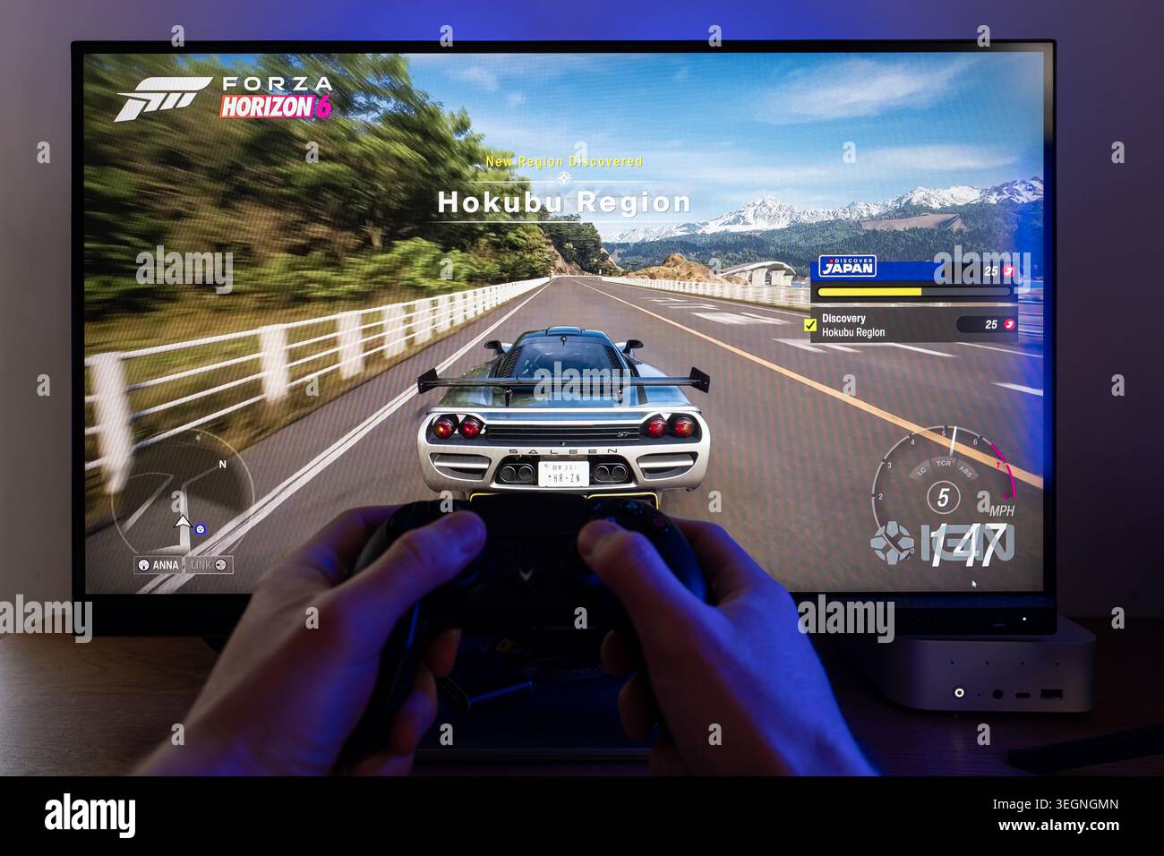 Gamer playing Forza Horizon 6 video game on a computer monitor using a ...
