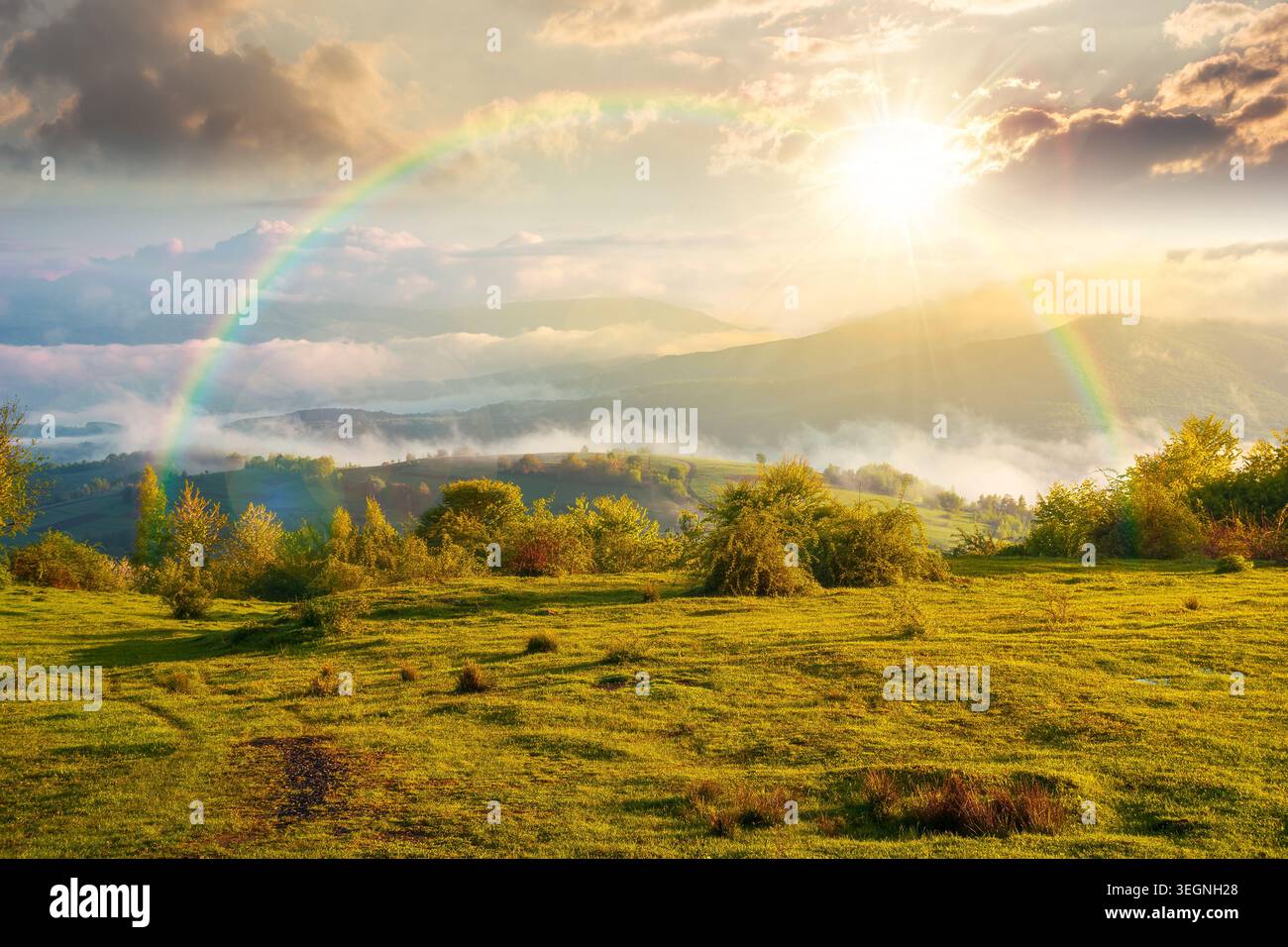 sunset over carpathian mountain landscape with fog. outdoor adventure image for stunning view of meadow. mountain field and rolling countryside valley Stock Photo