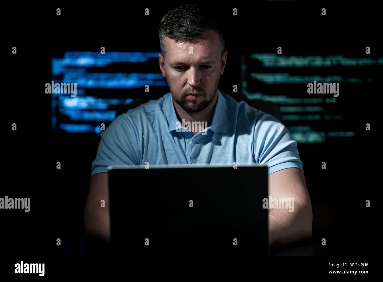 Hacker works on computer with focus. Hacker analyzes digital code in darkness. Hacker monitors network traffic activity. Hacker creates malware for Stock Photo