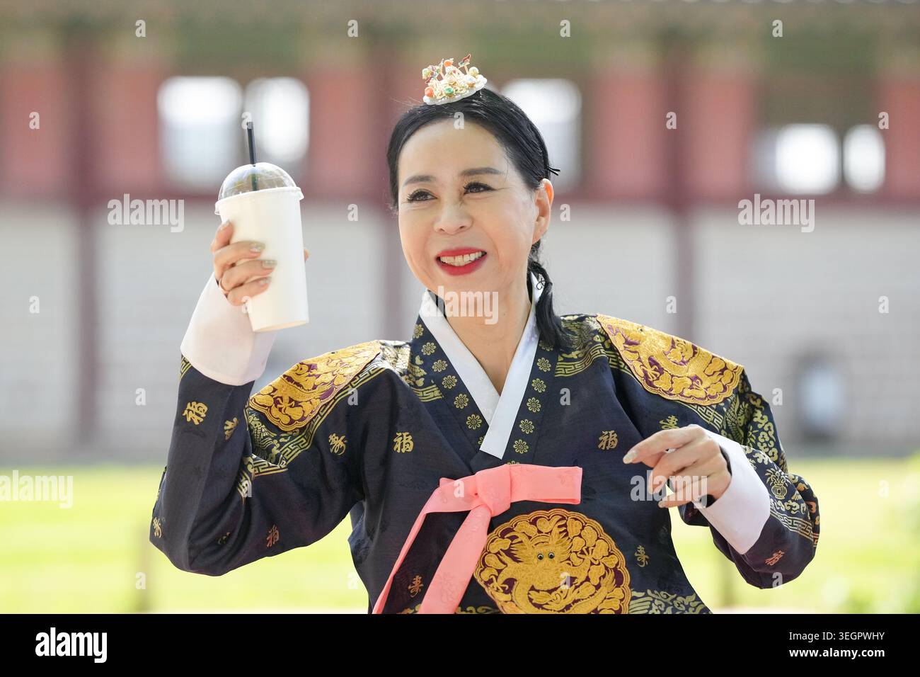 Woman smiles, holding drink in traditional Korean attire. Bright colors ...