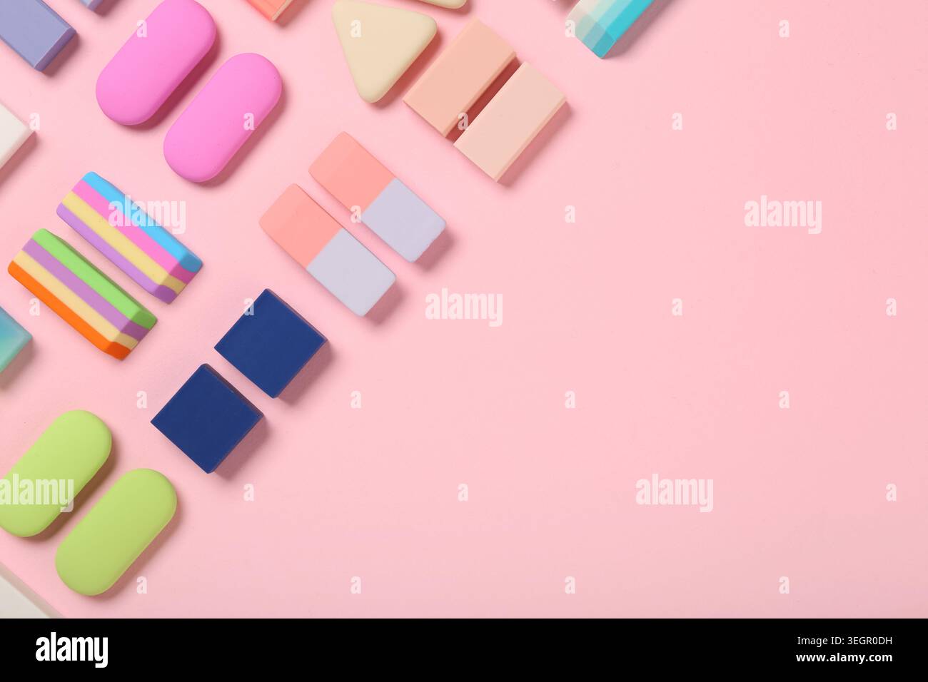 Many colorful rubber erasers on pink background Stock Photo