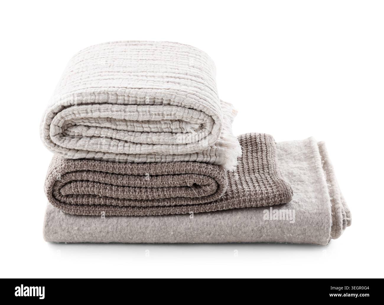 Stack of different cozy blankets isolated on white background Stock Photo