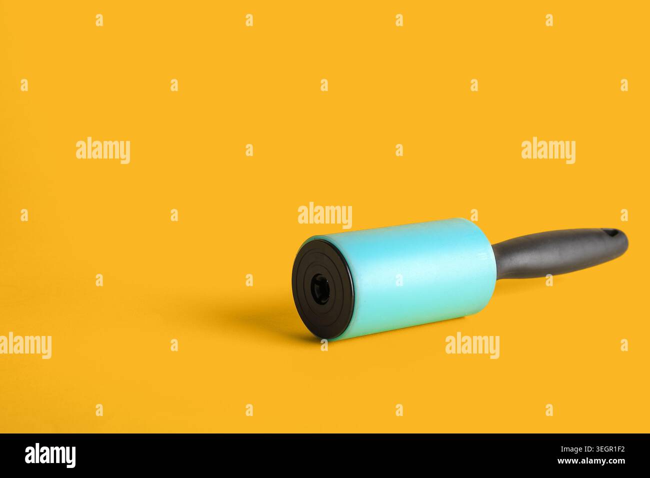 Lint roller on yellow background Stock Photo