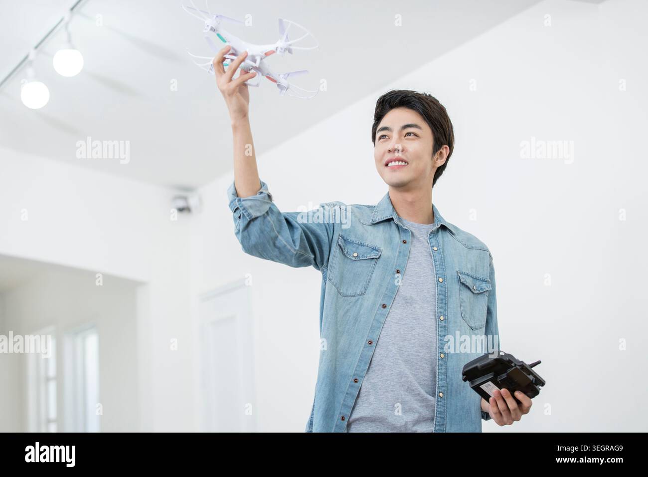 Smiling male Kidult playing with a drone Stock Photo