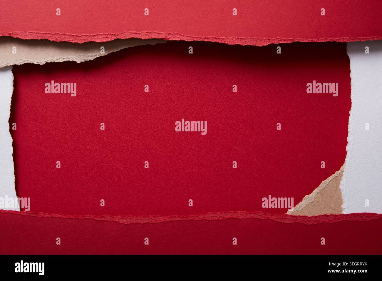 A red paper is torn in the middle, revealing a blank white space. Stock Photo