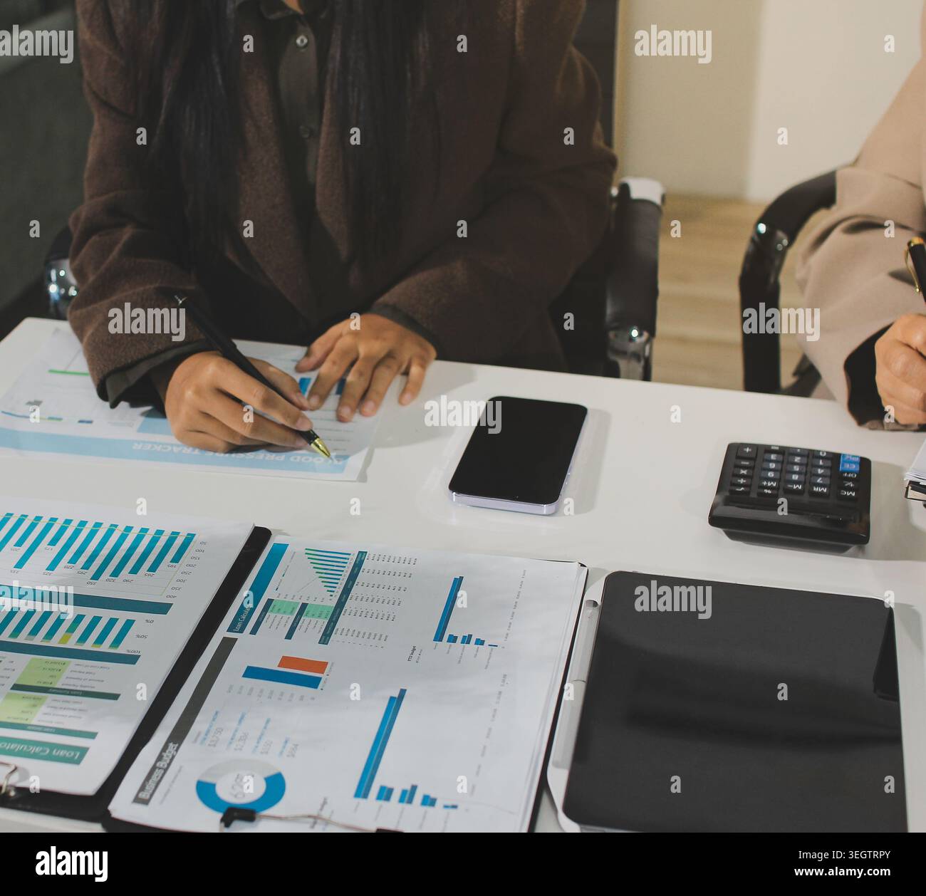 Two young Asian businesswomen discuss investment project working and ...