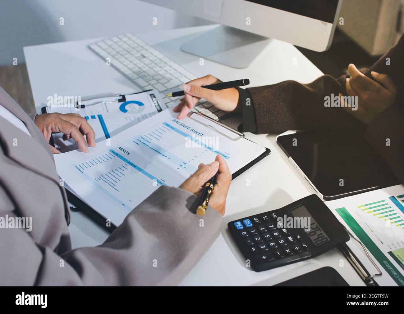 Two young Asian businesswomen discuss investment project working and ...
